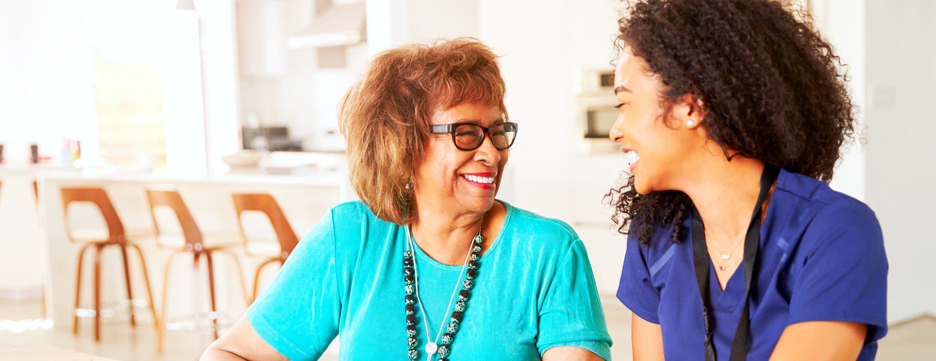 caregiver and senior woman wearing eyeglasses smiling